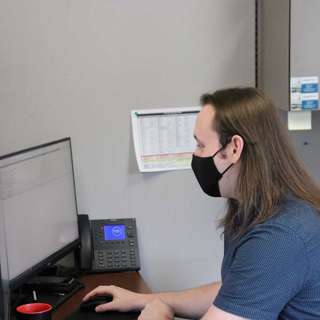 A Lakeland employee in front of a computer screen