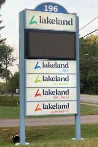 A photo of the sign in front of Lakeland Holdings' office in Bracebridge, with the logos of Lakeland Power, Lakeland Networks, Lakeland Solutions and Lakeland Generation