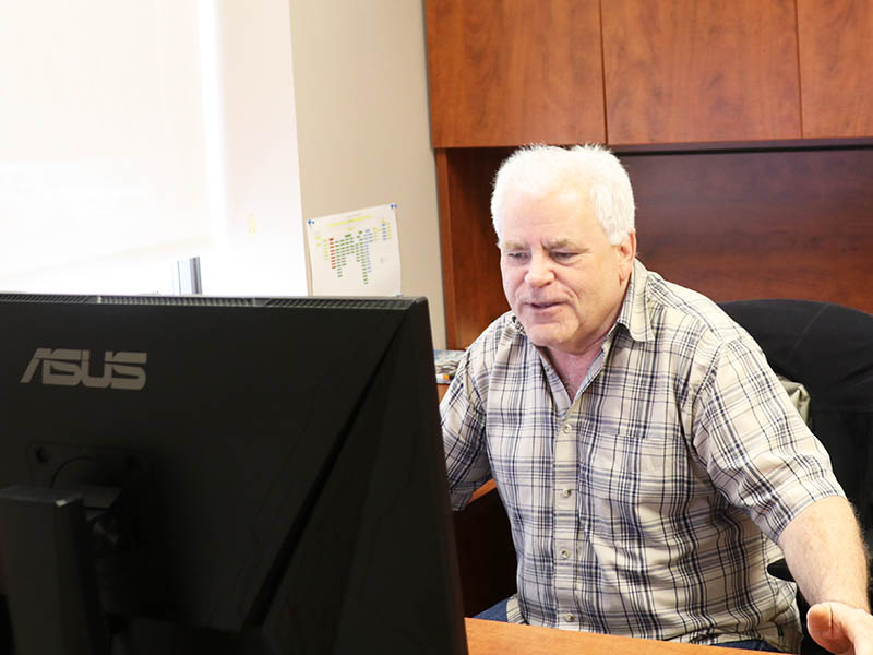 Lakeland Networks' Director of Business Development & Operations Dave Keith sitting at a desk looking at a computer monitor.